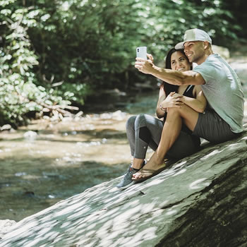 Couple taking selfie by river